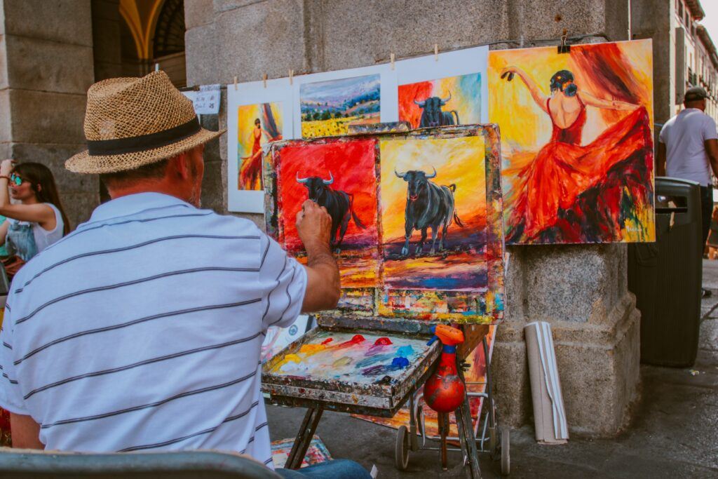 Best ways to make money online as an artist - Painter working on his paintings of bull fighters and spanish dancers
