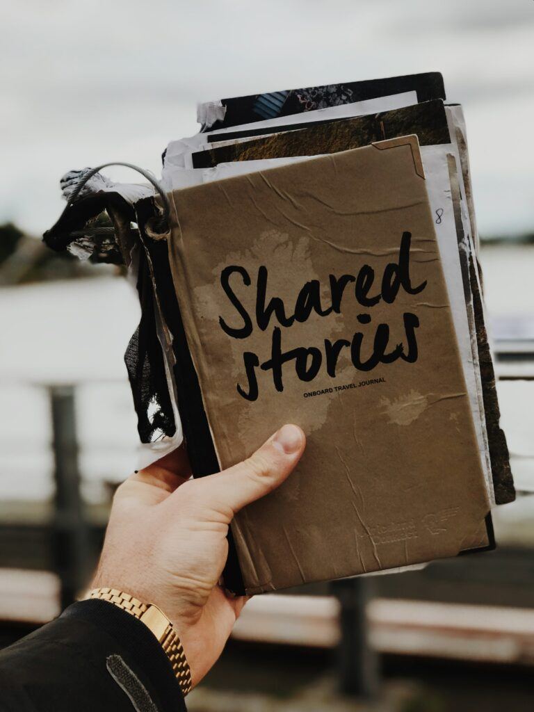 Best online business for writers and authors - man holding a worn scrap book titled: Shared Stories