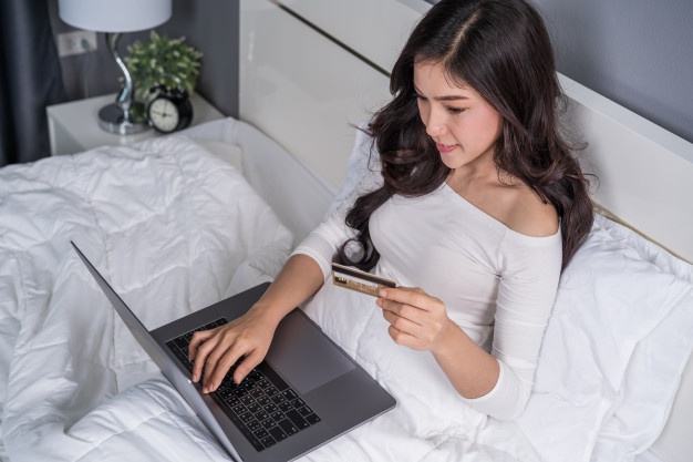 Wealthy Affiliate Review - Young lady working on her laptop in bed