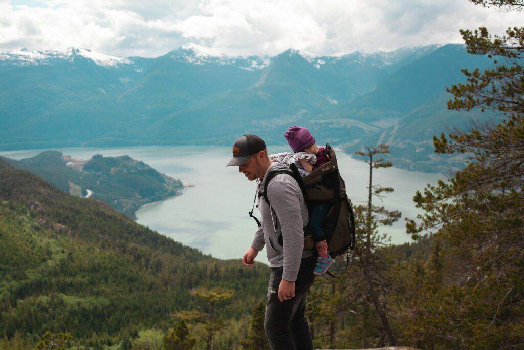 make money online from hiking - Man hiking with his baby on his back