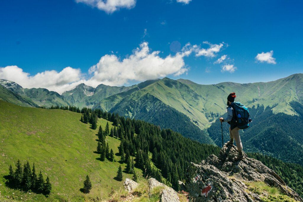 Make money online from hiking - man standing on the top of a moutain taking in the spectacular view