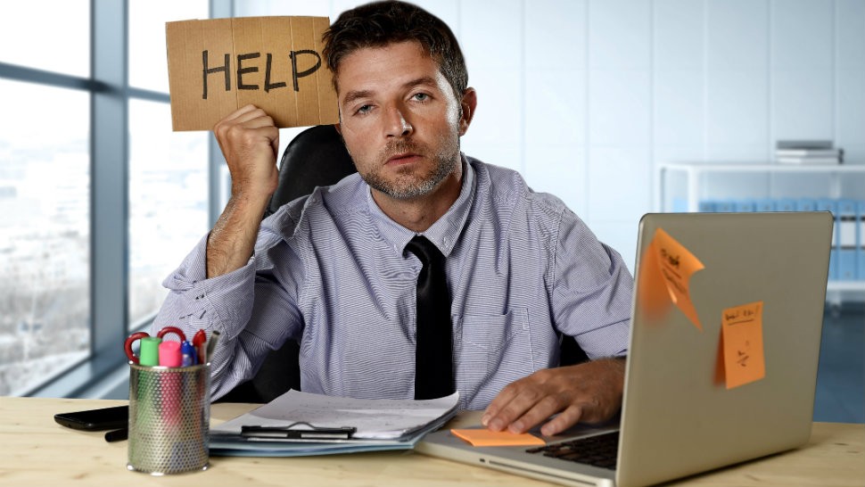 GetResponse website builder review - Man working at his laptop holding a sign that reads: HELP