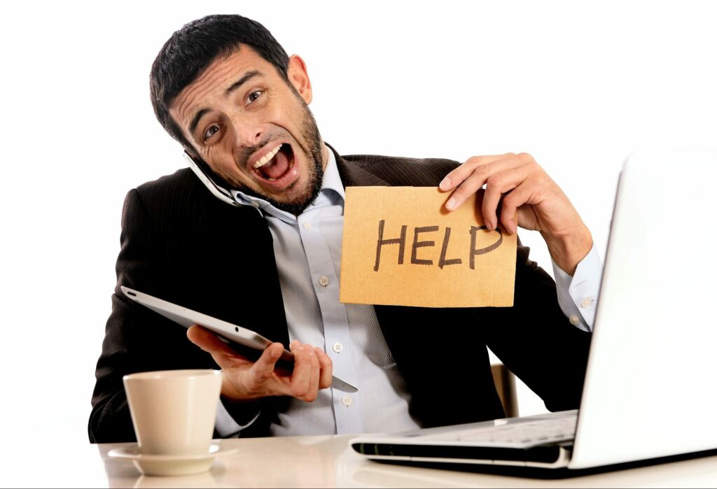 Man working online holding a cardboard sign that reads - HELP