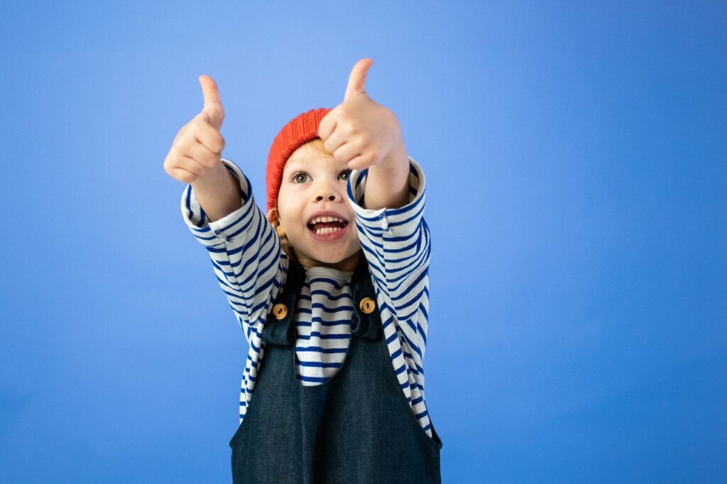 little boy giving the two thumbs up sign