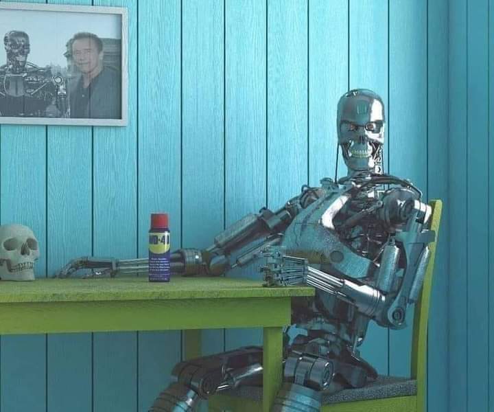 Terminator robot sitting at a table with a glass in its hand and a can of WD40 on the table