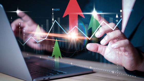 Passive income investments - someone working at their laptop with stock charts and indicators