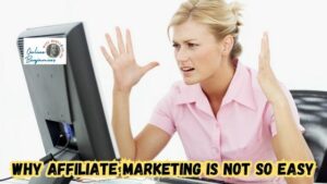 Why is affiliate marketing not that easy? Image of woman working at her desk with her hands up in frustration looking at her computer monitor.