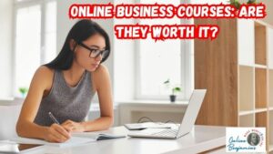 Featured image for "Are Online Business Courses Worth it?" Image of lady taking notes as she watches an online course on her laptop computer.